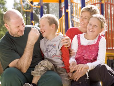 Inmate sitting and hugging two children and a woman